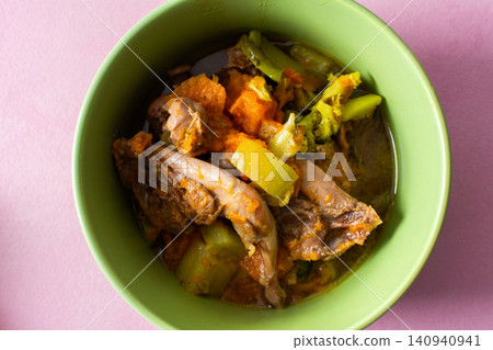 A bowl contains stewed quail mixed with fresh vegetables such as carrots, broccoli, and zucchini. This meal is prepared for breakfast or lunch and offers protein and nutrition A bowl contains stewed quail mixed with fresh vegetables such as carrots, broccoli, and zucchini. This meal is prepared for breakfast or lunch and offers protein and nutrition 140940941