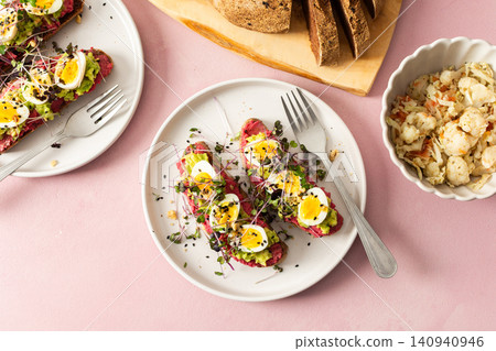 Sandwiches made with gluten-free bread topped with beetroot hummus, pesto, sliced quail eggs, and microgreens. Served with a side of coleslaw and whole grain bread Sandwiches made with gluten-free bread topped with beetroot hummus, pesto, sliced quail eggs, and microgreens. Served with a side of coleslaw and whole grain bread 140940946