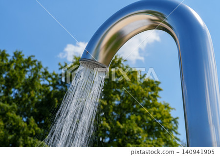 Outdoor pool shower with water stream against blue sky Outdoor pool shower with water stream against blue sky 140941905