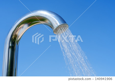 Outdoor pool shower with water stream against blue sky Outdoor pool shower with water stream against blue sky 140941906