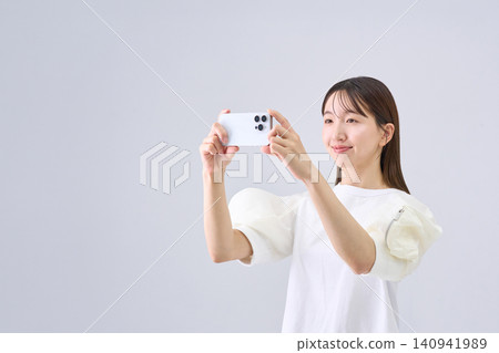 日本女子正用智慧型手機看視頻 日本女子正用智慧型手機看視頻 140941989