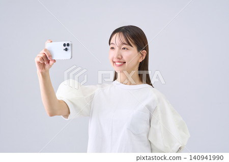 Japanese woman watching video on her smartphone Japanese woman watching video on her smartphone 140941990