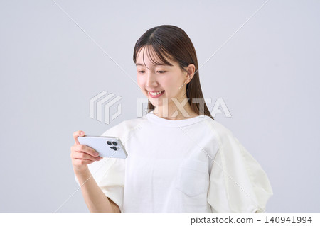 日本女子正用智慧型手機看視頻 日本女子正用智慧型手機看視頻 140941994