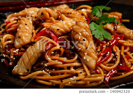 udon noodles, with squid and vegetables, on a black plate, homemade, no people, udon noodles, with squid and vegetables, on a black plate, homemade, no people, 140942320