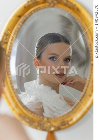 Woman reflecting on beauty and elegance in mirror Woman reflecting on beauty and elegance in mirror 140942370