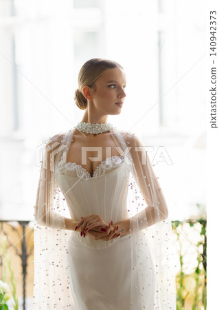 Elegant bride wearing pearl embellished wedding dress and choker Elegant bride wearing pearl embellished wedding dress and choker 140942373