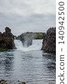 Hjalparfoss waterfall in South Iceland, framed by rugged basalt rocks. 140942500