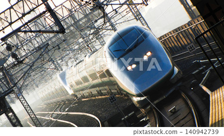 A photograph of a combined Shinkansen train, "Tsubasa" and "Max Yamabiko," approaching Omiya Station, bathed in the strong morning sun. A photograph of a combined Shinkansen train, "Tsubasa" and "Max Yamabiko," approaching Omiya Station, bathed in the strong morning sun. 140942739