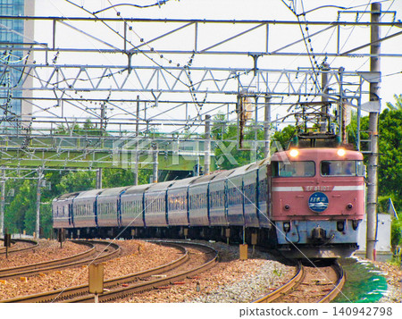 The "Nihonkai" sleeper express train, pulled by an EF81-type locomotive in rose pink (JNR livery), travels on the Tokaido Main Line towards Osaka. The "Nihonkai" sleeper express train, pulled by an EF81-type locomotive in rose pink (JNR livery), travels on the Tokaido Main Line towards Osaka. 140942798