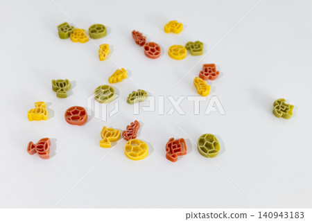 Colorful pasta pieces with football themed shapes scattered on a white surface, creating playful, child friendly food art. Colorful pasta pieces with football themed shapes scattered on a white surface, creating playful, child friendly food art. 140943183