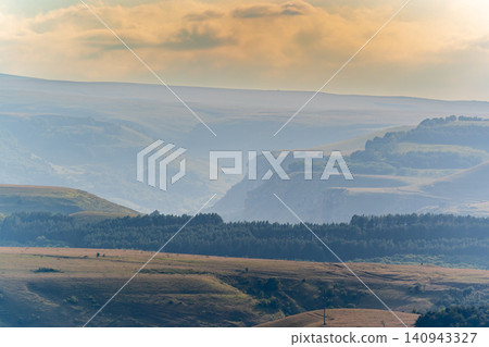 Layers of green mountains and hills in the haze during sunset. Panoramic View of Green hills and Meadow. Layers of green mountains and hills in the haze during sunset. Panoramic View of Green hills and Meadow. 140943327