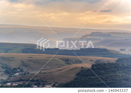 Layers of green mountains and hills in the haze during sunset. Panoramic View of Green hills and Meadow. Layers of green mountains and hills in the haze during sunset. Panoramic View of Green hills and Meadow. 140943337
