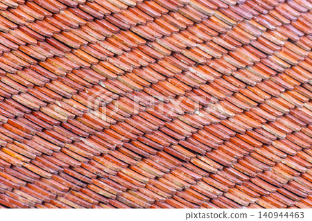 Weathered terracotta roof tiles forming detailed repeating texture warm earthy tones ideal for architecture backgrounds construction design pattern use 140944463