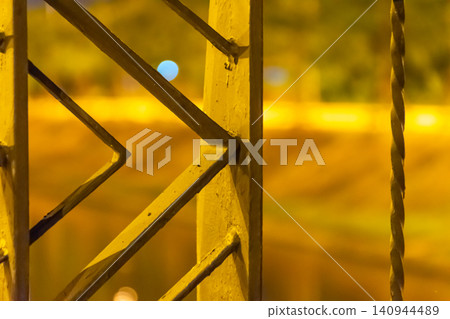 Closeup of illuminated steel structure at night geometric lines warm lighting soft bokeh background highlighting industrial architecture engineering details Closeup of illuminated steel structure at night geometric lines warm lighting soft bokeh background highlighting industrial architecture engineering details 140944489