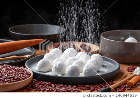 traditional Chinese Tangyuan making process, flour sifting over sweet glutinous rice balls traditional Chinese Tangyuan making process, flour sifting over sweet glutinous rice balls 140944619