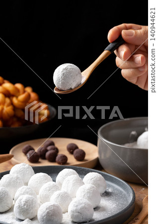 rolling sweet glutinous rice ball in hand, traditional handmade Tangyuan mochi preparation rolling sweet glutinous rice ball in hand, traditional handmade Tangyuan mochi preparation 140944621