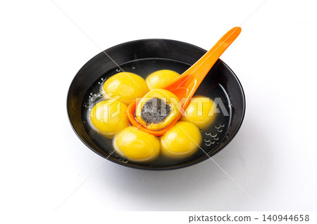 cooked yellow millet Tangyuan with black sesame filling, traditional Chinese sweet rice ball cross section cooked yellow millet Tangyuan with black sesame filling, traditional Chinese sweet rice ball cross section 140944658
