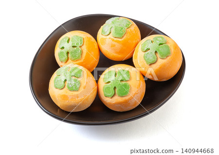 frozen raw persimmon shaped sweet rice balls, uncooked orange Tangyuan with black sesame filling for Chinese New Year frozen raw persimmon shaped sweet rice balls, uncooked orange Tangyuan with black sesame filling for Chinese New Year 140944668
