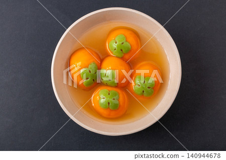 cooked persimmon shaped sweet rice ball with flowing black sesame filling, authentic festive Chinese Tangyuan dessert cooked persimmon shaped sweet rice ball with flowing black sesame filling, authentic festive Chinese Tangyuan dessert 140944678