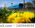 一列特快列車沿著兩旁盛開著蒲公英的鐵軌行駛。 140944698