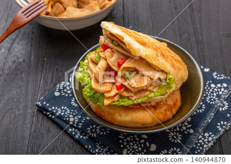 chinese sesame flatbread sandwich stuffed with spicy vegetarian chicken wings, traditional street food burger chinese sesame flatbread sandwich stuffed with spicy vegetarian chicken wings, traditional street food burger 140944870