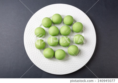 raw green glutinous rice dough balls, prepared mugwort infused dough spheres for making Qingtuan mochi 140945077
