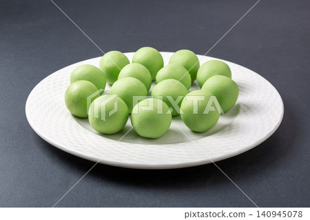 raw green glutinous rice dough balls, prepared mugwort infused dough spheres for making Qingtuan mochi raw green glutinous rice dough balls, prepared mugwort infused dough spheres for making Qingtuan mochi 140945078