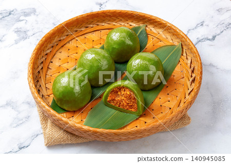 traditional green rice balls with salted egg yolk and pork floss filling, savory Qingtuan mochi on bamboo mat traditional green rice balls with salted egg yolk and pork floss filling, savory Qingtuan mochi on bamboo mat 140945085