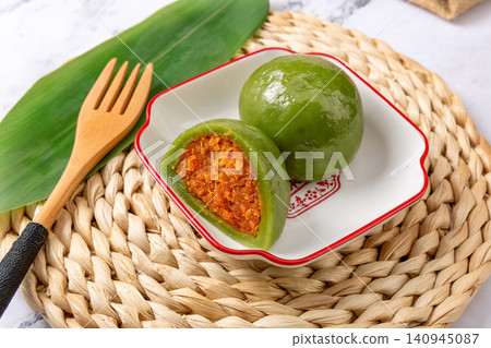 traditional green rice balls with salted egg yolk and pork floss filling, savory Qingtuan mochi on bamboo mat traditional green rice balls with salted egg yolk and pork floss filling, savory Qingtuan mochi on bamboo mat 140945087