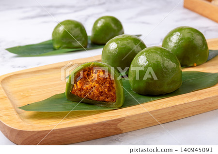 traditional green rice balls with salted egg yolk and pork floss filling, savory Qingtuan mochi on bamboo mat traditional green rice balls with salted egg yolk and pork floss filling, savory Qingtuan mochi on bamboo mat 140945091