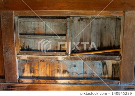Locking the wooden gate with a support rod. Locking the wooden gate with a support rod. 140945289