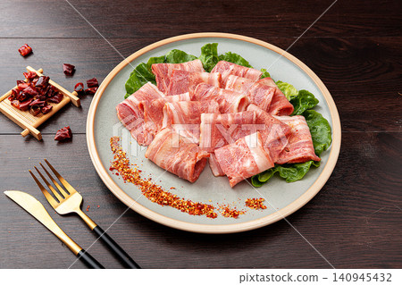 uncooked bacon meat rolls with chili flakes and spices, delicious savory meat skewers for BBQ or Asian street food. uncooked bacon meat rolls with chili flakes and spices, delicious savory meat skewers for BBQ or Asian street food. 140945432