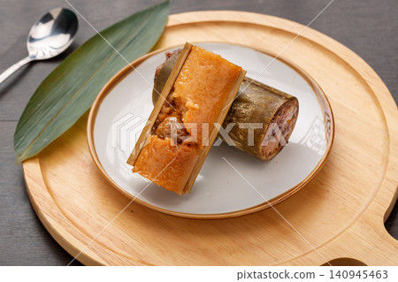 steamed sweet glutinous rice zongzi infused with candied honey dates and bamboo aroma. steamed sweet glutinous rice zongzi infused with candied honey dates and bamboo aroma. 140945463