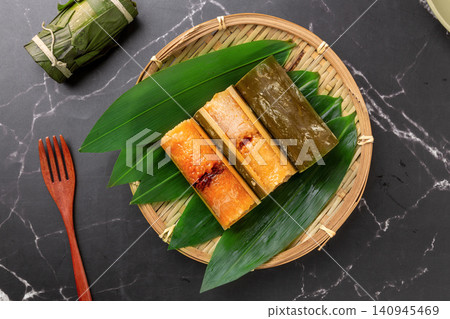 steamed sweet glutinous rice zongzi cooked in bamboo tube and filled with red dates. steamed sweet glutinous rice zongzi cooked in bamboo tube and filled with red dates. 140945469