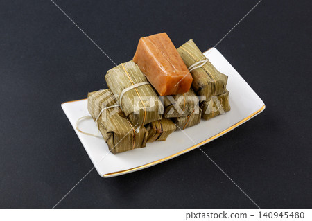 sichuan traditional Huangba, a steamed sweet cake made of glutinous rice and soybean flour wrapped in bamboo leaves. sichuan traditional Huangba, a steamed sweet cake made of glutinous rice and soybean flour wrapped in bamboo leaves. 140945480
