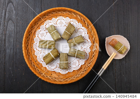 sichuan traditional Huangba, a steamed sweet cake made of glutinous rice and soybean flour wrapped in bamboo leaves. sichuan traditional Huangba, a steamed sweet cake made of glutinous rice and soybean flour wrapped in bamboo leaves. 140945484