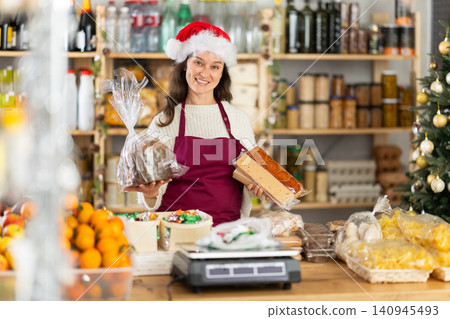 Woman seller offering sweets in decorated grocery store Woman seller offering sweets in decorated grocery store 140945493