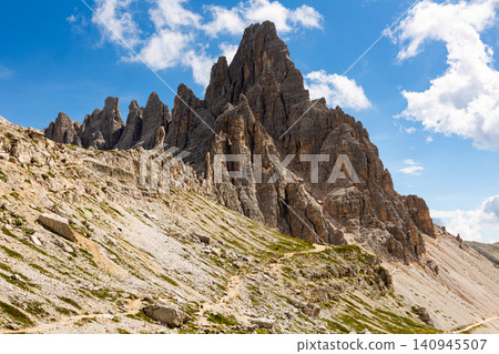 Narrow footpaths cross mountainous terrain on Paternkofel pick, rare travelers on way to top 140945507