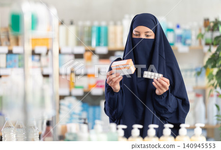 Young woman in hijab chooses pills Young woman in hijab chooses pills 140945553