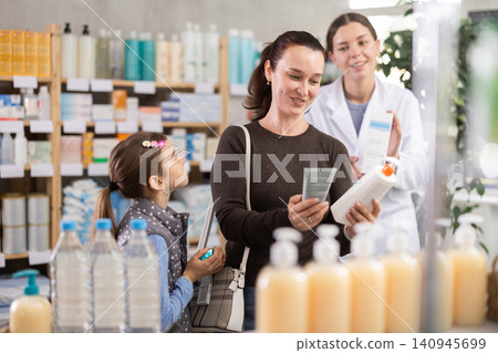 Woman with barrel choosing cream in pharmacy with seller Woman with barrel choosing cream in pharmacy with seller 140945699