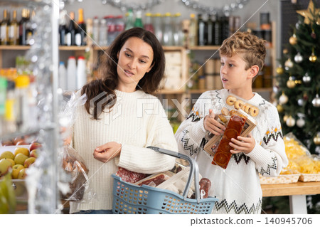 Mother and her son choose different products together for Christmas celebration in grocery supermarket Mother and her son choose different products together for Christmas celebration in grocery supermarket 140945706