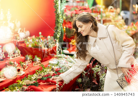 Happy woman choosing gifts and decorations at street Christmas fair Happy woman choosing gifts and decorations at street Christmas fair 140945743