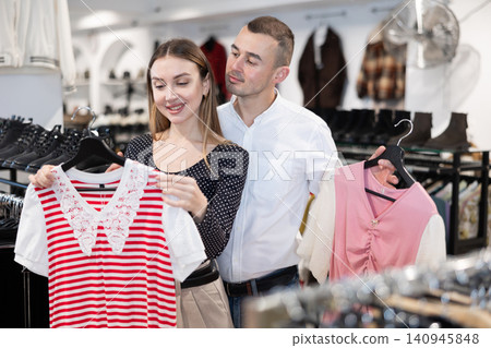 Couple young woman and young man choosing blouse Couple young woman and young man choosing blouse 140945848