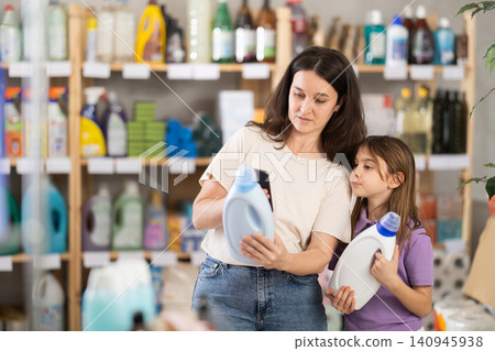 Woman and girl clients, by scanning QR code, gains access to information about liquid detergent Woman and girl clients, by scanning QR code, gains access to information about liquid detergent 140945938