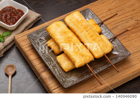 deep fried crispy rice cake skewers garnished with fresh mint leaf. deep fried crispy rice cake skewers garnished with fresh mint leaf. 140946090