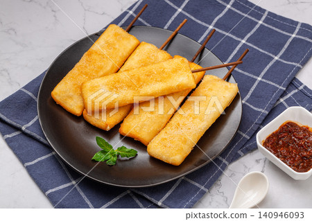 deep fried crispy rice cake skewers garnished with fresh mint leaf. deep fried crispy rice cake skewers garnished with fresh mint leaf. 140946093