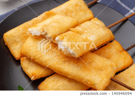 deep fried crispy rice cake skewers garnished with fresh mint leaf. deep fried crispy rice cake skewers garnished with fresh mint leaf. 140946094