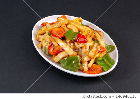 stir fried sliced rice cakes with mushrooms, vegetables and meat in spicy sauce. 140946113