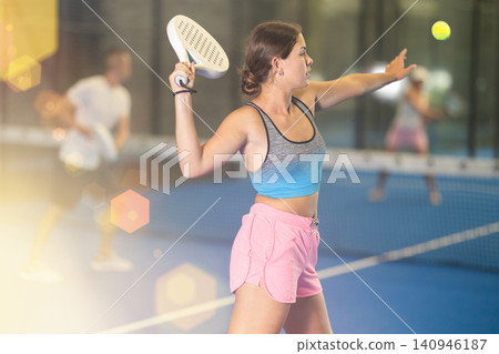 Young woman and man playing tennis against woman Young woman and man playing tennis against woman 140946187