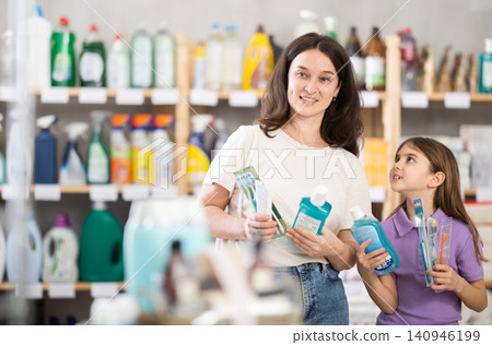 Woman with daughter choosing dental care products Woman with daughter choosing dental care products 140946199